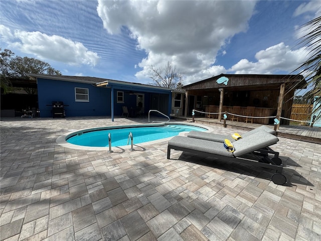 outdoor pool featuring a patio and grilling area