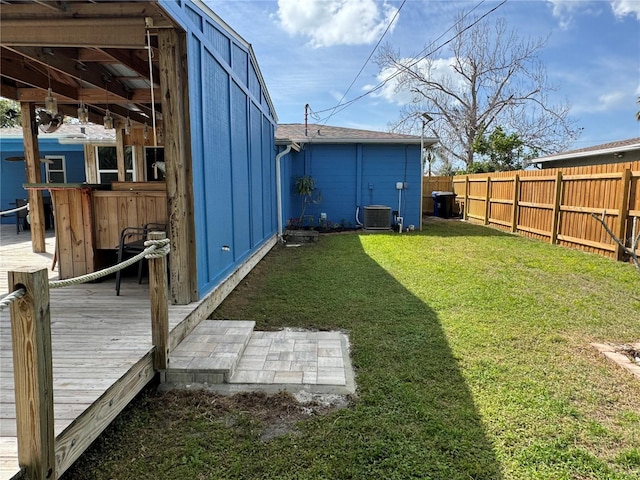 view of yard featuring an outdoor structure, a fenced backyard, and central air condition unit