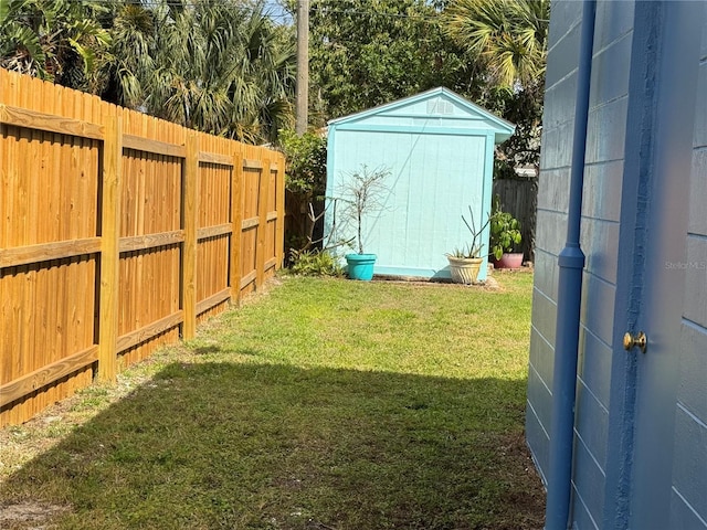 view of yard featuring an outbuilding, a storage unit, and a fenced backyard