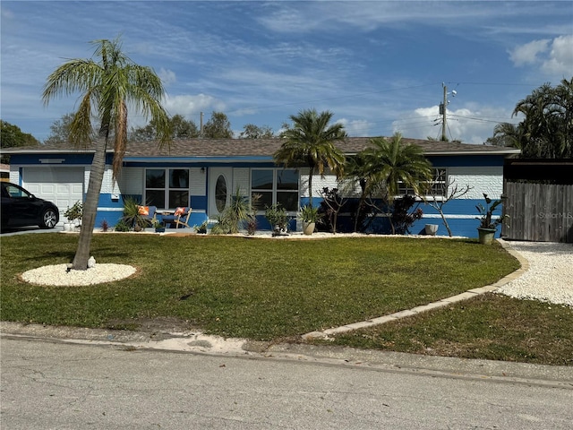 ranch-style home featuring a garage and a front yard