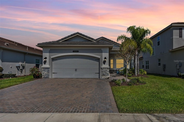 view of front of property with a garage, stone siding, decorative driveway, a front yard, and stucco siding