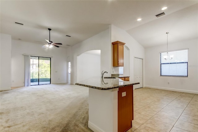 kitchen with brown cabinetry, light colored carpet, visible vents, and a sink