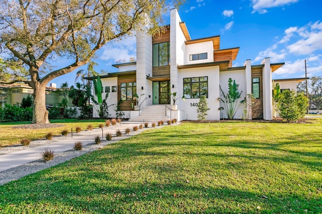 modern home featuring a front yard and stucco siding