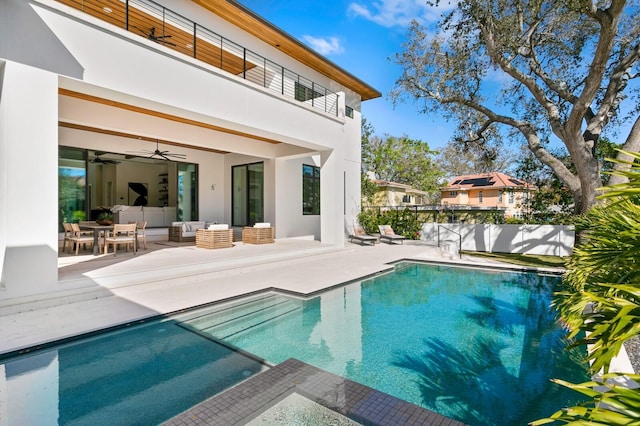 back of property featuring ceiling fan, a patio, a balcony, outdoor lounge area, and fence