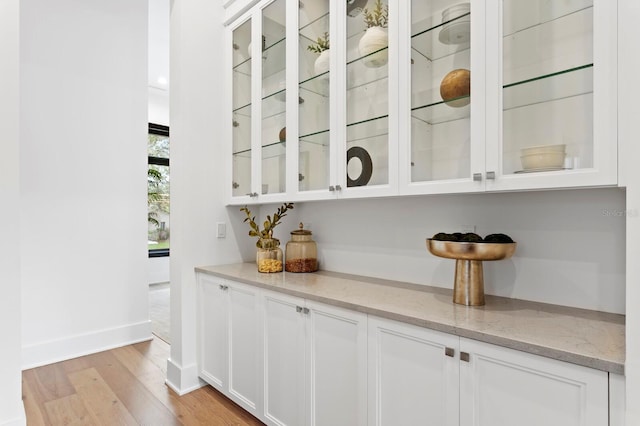 bar with light wood-style flooring and baseboards