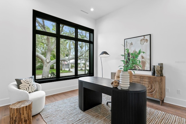 office area with visible vents, a wealth of natural light, and baseboards