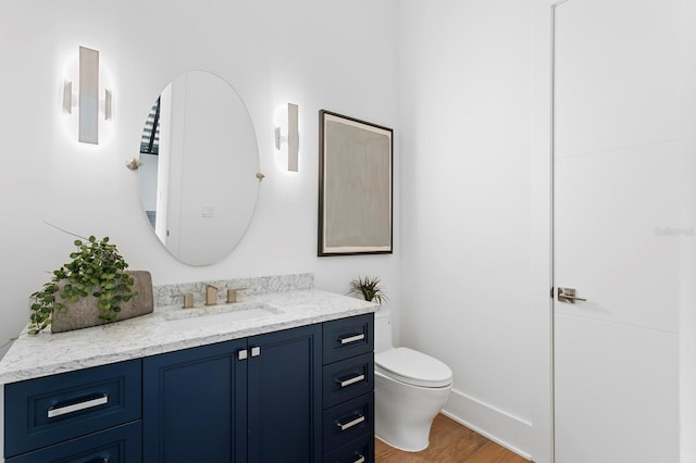 bathroom featuring vanity, toilet, and wood finished floors