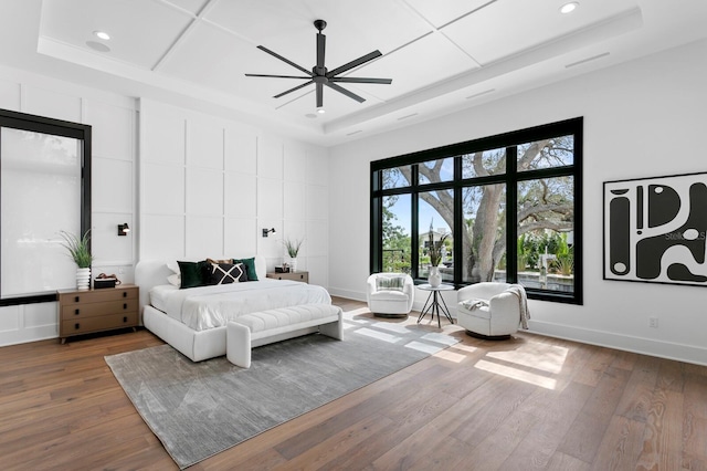bedroom with recessed lighting, a ceiling fan, baseboards, wood-type flooring, and a raised ceiling