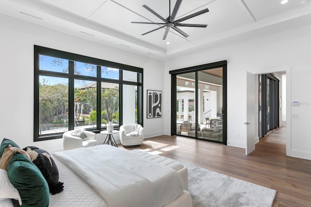 bedroom with access to outside, multiple windows, baseboards, and wood finished floors
