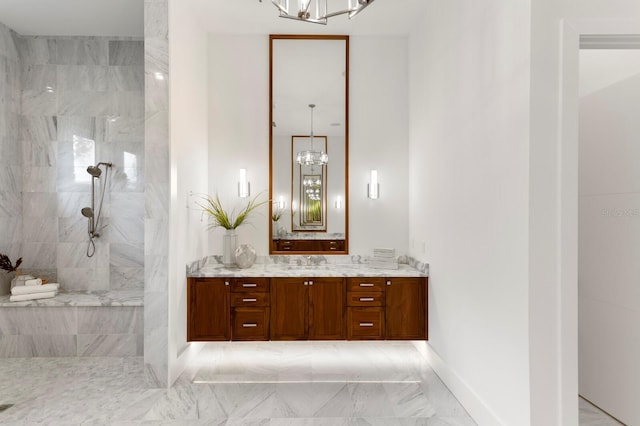 bathroom with marble finish floor, vanity, baseboards, and walk in shower