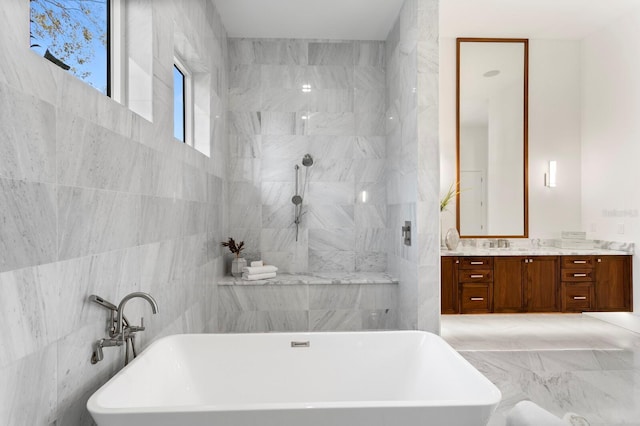 full bath featuring a soaking tub, walk in shower, vanity, and tile walls