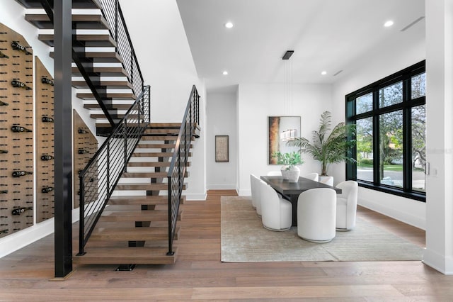dining room featuring stairway, baseboards, wood finished floors, and recessed lighting