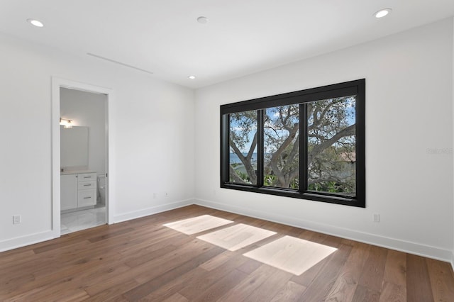 unfurnished bedroom with recessed lighting, baseboards, and wood finished floors