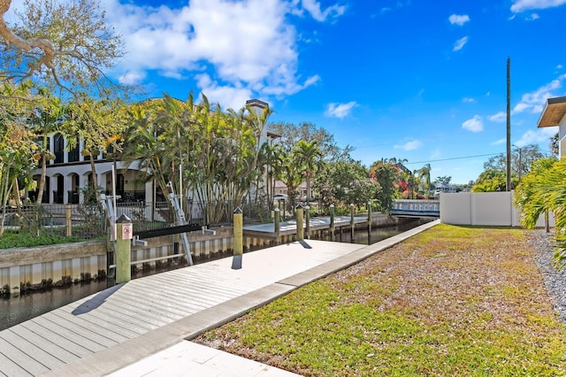 surrounding community featuring a boat dock and fence