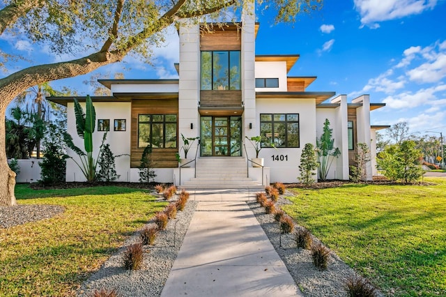 contemporary home featuring a front lawn and stucco siding