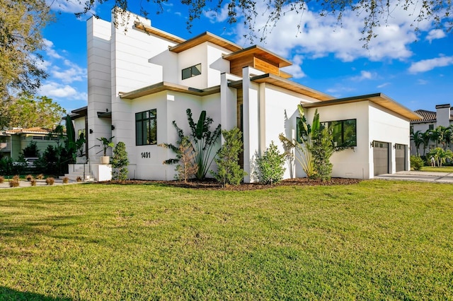 view of home's exterior featuring a garage, driveway, a lawn, and stucco siding