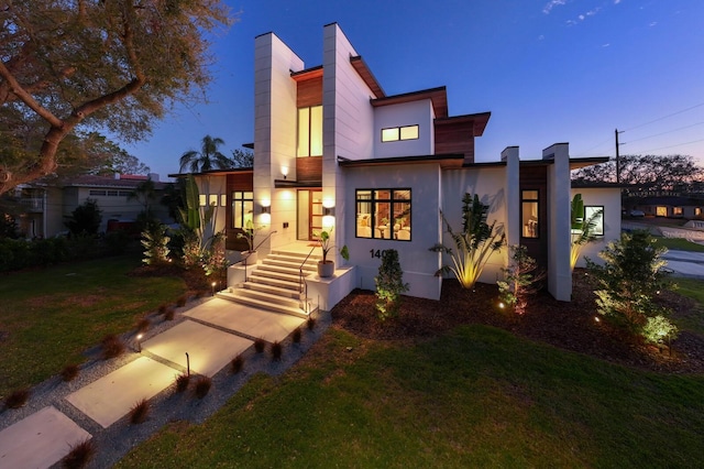 contemporary home with a yard and stucco siding