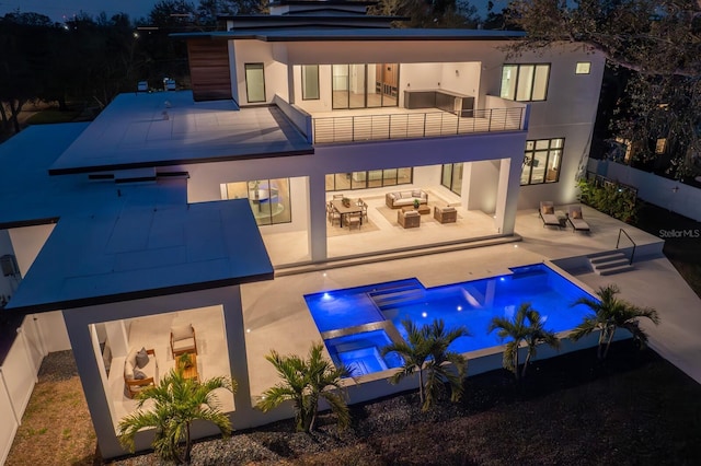 rear view of property with a patio, a balcony, a fenced backyard, outdoor lounge area, and stucco siding