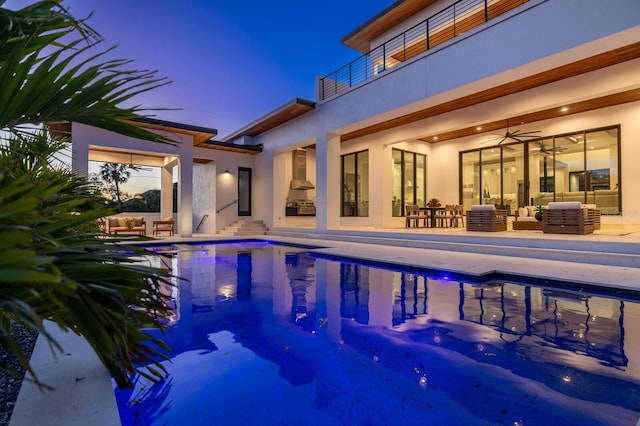 pool featuring a patio area, an outdoor hangout area, and a ceiling fan