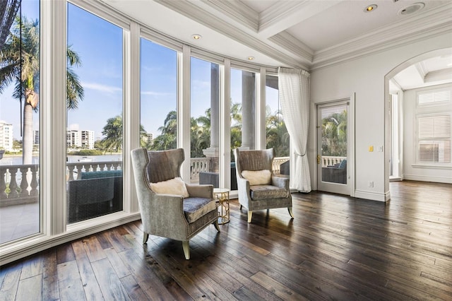 sunroom / solarium featuring arched walkways and beam ceiling