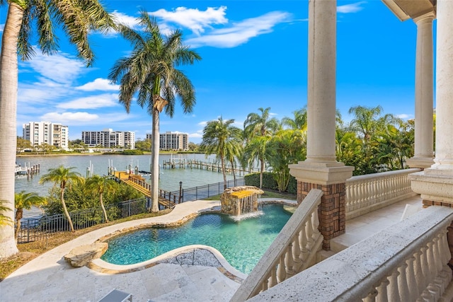 view of swimming pool with a dock, a water view, boat lift, and fence