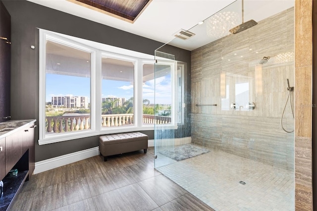 bathroom featuring baseboards, a walk in shower, and vanity