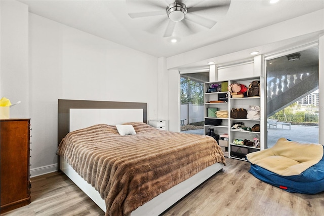 bedroom featuring baseboards, access to outside, a ceiling fan, and wood finished floors