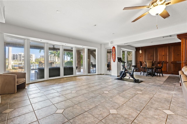 interior space with ceiling fan, light tile patterned floors, and visible vents