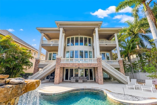 rear view of house with stairway, a patio area, a balcony, and an outdoor living space