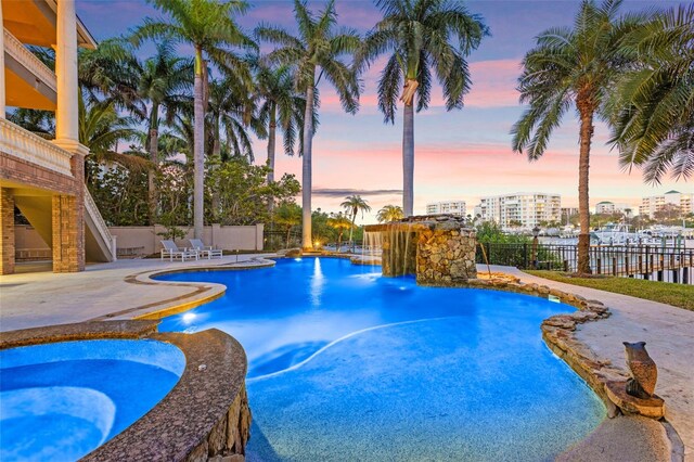 pool at dusk featuring a patio area, fence, and a fenced in pool