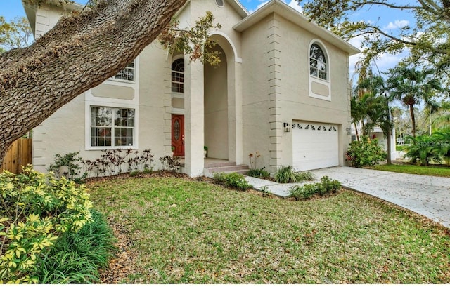 view of front of property featuring driveway, an attached garage, a front yard, and stucco siding