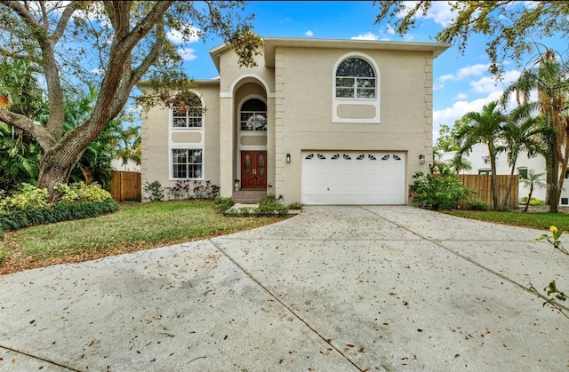 traditional home featuring fence, a garage, driveway, and stucco siding