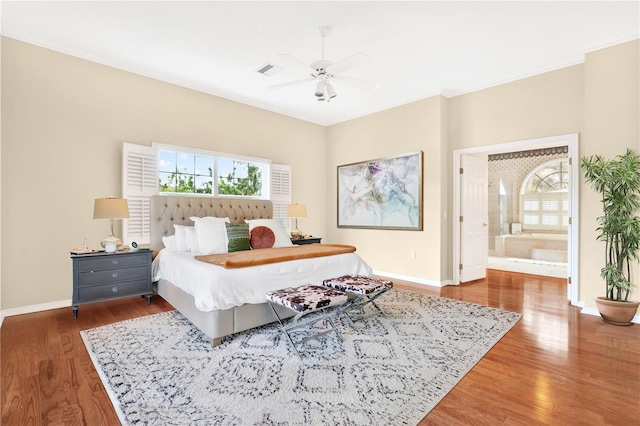 bedroom with visible vents, crown molding, baseboards, and wood finished floors