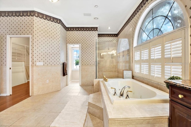 full bathroom with a tub with jets, tile patterned floors, walk in shower, crown molding, and vanity