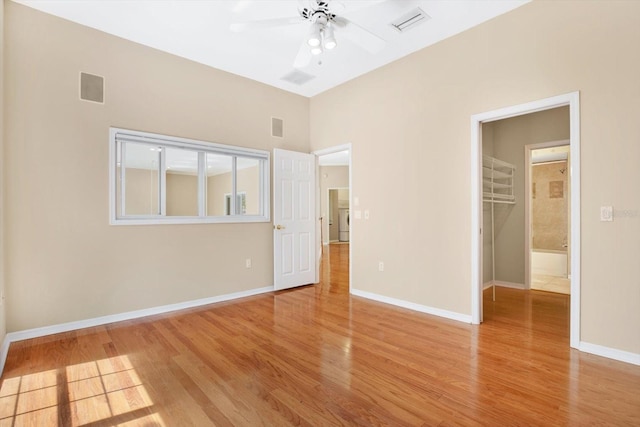 empty room featuring light wood-type flooring, baseboards, visible vents, and a ceiling fan