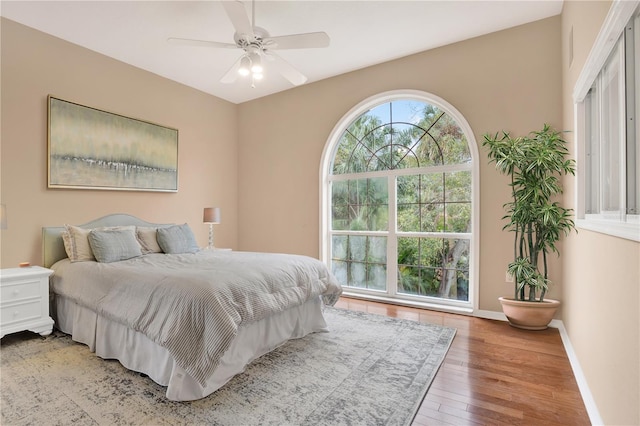 bedroom featuring light wood-style floors, ceiling fan, and baseboards