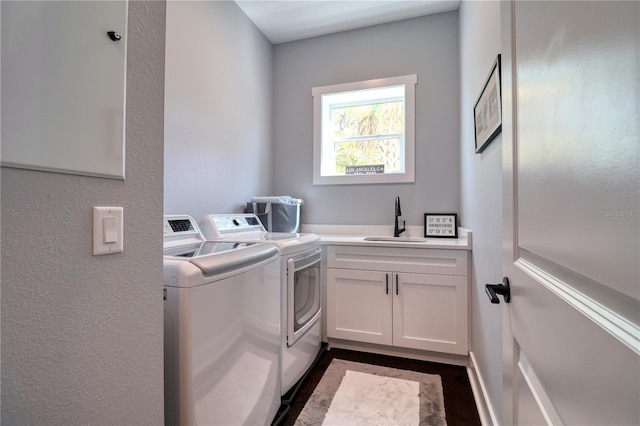 clothes washing area featuring cabinet space, washer and clothes dryer, and a sink