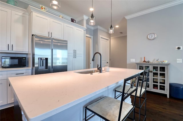 kitchen with dark wood finished floors, stainless steel refrigerator with ice dispenser, a kitchen island with sink, a sink, and black microwave