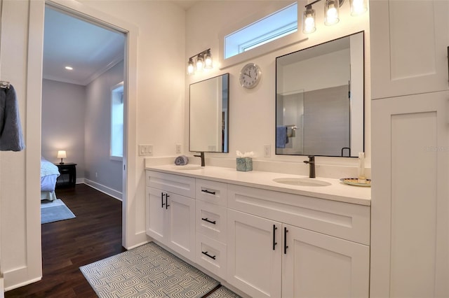 bathroom with double vanity, ornamental molding, a sink, and wood finished floors