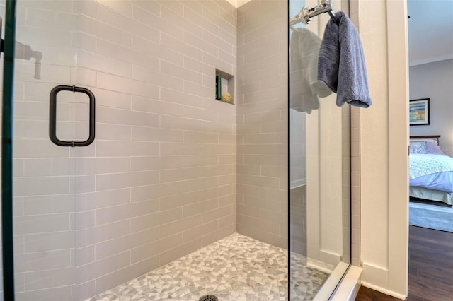 full bathroom with a stall shower, ensuite bath, and wood finished floors