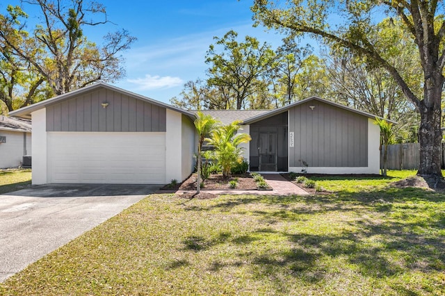 mid-century inspired home featuring a garage, driveway, a front lawn, and fence