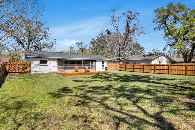 rear view of property with a yard, a fenced backyard, and a sunroom