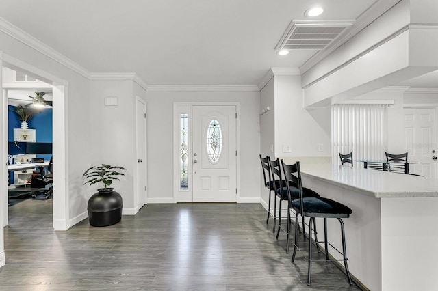 entryway with dark wood-style floors, visible vents, and ornamental molding