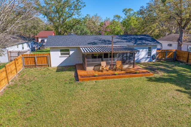 rear view of property featuring a deck, a gate, a lawn, and a fenced backyard