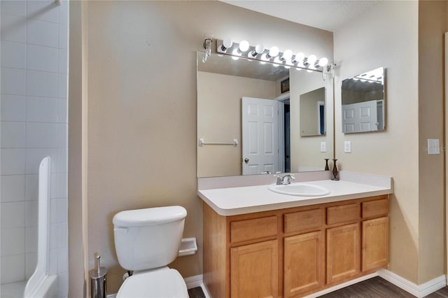 bathroom featuring wood finished floors, vanity, toilet, and baseboards