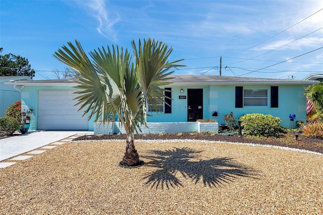 ranch-style house with driveway, an attached garage, and stucco siding