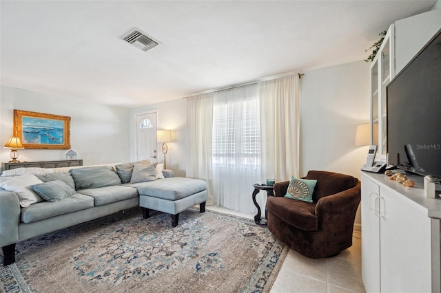 living area with visible vents and light tile patterned flooring