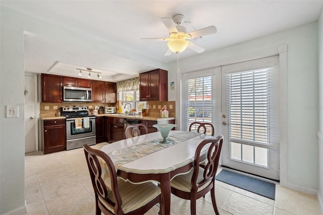 dining space featuring ceiling fan, french doors, light tile patterned floors, and baseboards