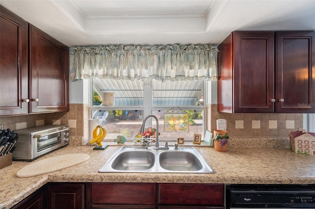 kitchen with dishwashing machine, a toaster, a sink, light countertops, and a tray ceiling