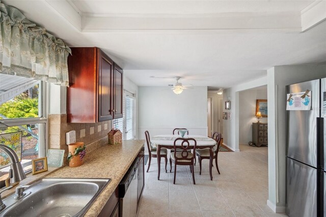 kitchen featuring light tile patterned floors, tasteful backsplash, dishwasher, freestanding refrigerator, and a sink